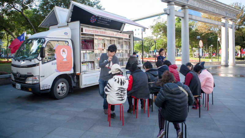 書車前左起：生奶（詩人，島座放送有限公司負責人）與柯姿安（藝術家），他們尚不知突來大風是閱讀活動最大的挑戰。